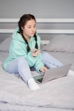 Uzaktan kumandalı ya da evden uzak çalışmalı. Yatakta dizüstü bilgisayarlı esmer bir kadın. Karantina kısıtlamaları. covid-19 salgını