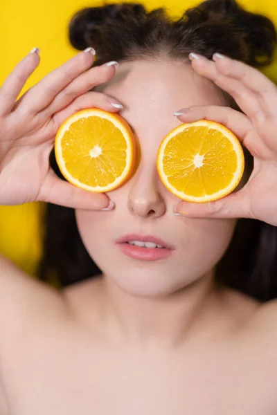 Joven morena chica con rebanada de fruta naranja cerca de la cara de la piel sobre fondo amarillo. sabrosa fruta jugosa. Frutas tropicales, comida saludable. rebanada de cítricos. fruta jugosa sabrosa — Foto de Stock