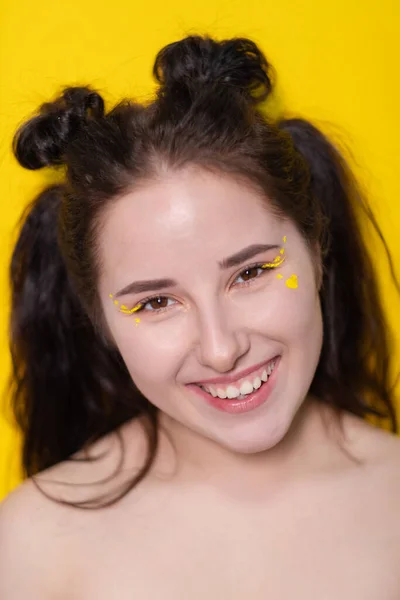 Portré vonzó barna nő kis szív az arcon sárga háttér. portré gyönyörű lány színes háttér — Stock Fotó