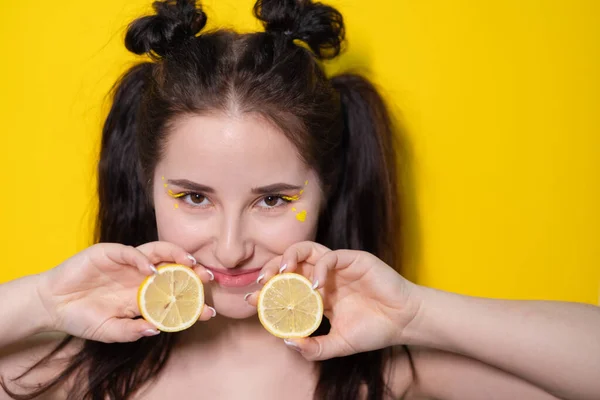 Morena chica con limón cerca de la cara de la piel sobre fondo amarillo. sabrosa fruta jugosa. Frutas tropicales, comida saludable. rebanada de cítricos — Foto de Stock