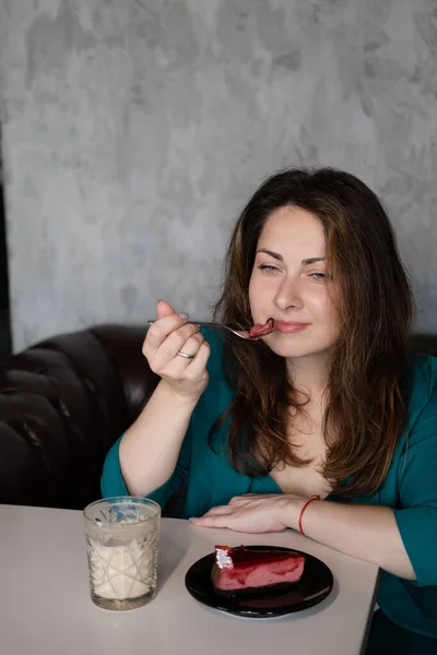 コーヒーとデザートが入った緑色のスーツの女性 コーヒー休憩 カフェやレストランで働く女性は — ストック写真