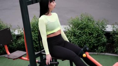 Siyah ve yeşil spor kıyafetleri içinde spor salonunda spor egzersizleri yapan bir kadın. Mükemmel sağlıklı ince vücut..