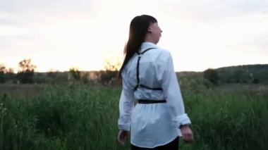 Parlayan Güneş. Farkındalık, pozitif akıl, şimdiki zamanda yaşamak, yavaş yaşam. Gün batımında genç mutlu bir kadının açık hava portresi..