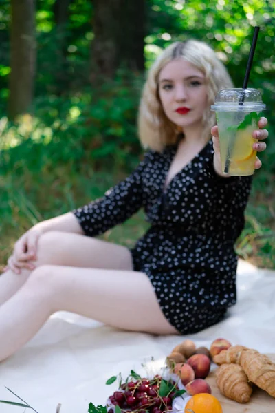 Гарна Блондинка Пікніку Білому Плащі Парку Пластиковою Прозорою Чашкою Лимонадом — стокове фото