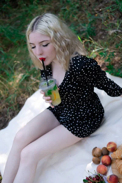 Csinos Szőke Lány Piknik Fehér Kockás Parkban Egy Műanyag Átlátszó — Stock Fotó