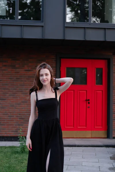 Чарівна Молода Жінка Чорній Сукні Перед Сучасною Будівлею Червоними Дверима — стокове фото