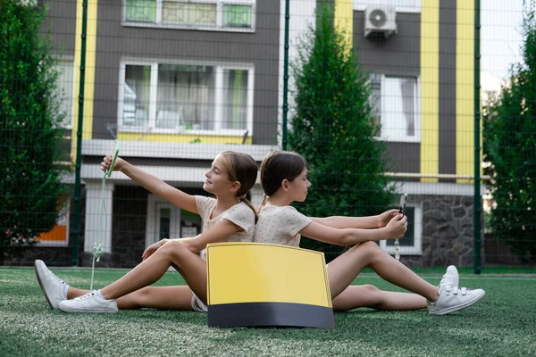 Twee Tienermeisjes Die Buiten Smartphones Gebruiken Buurt Van Zwart Geel — Stockfoto