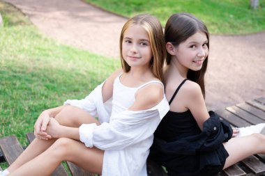 sisterhood. two sisters or friends spending time outdoors on sunny summer day. bff, sibling, girlfriend. millennial teen.