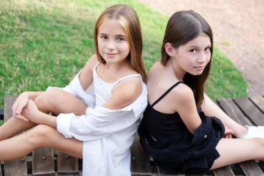 sisterhood. two sisters or friends spending time outdoors on sunny summer day. bff, sibling, girlfriend. millennial teen.