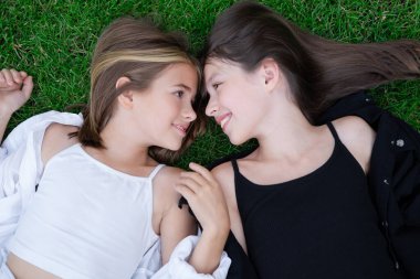 happy and lucky to have a sister. two girls outdoors in black and white clothes. good and bad. obedient and harmful. fraternal twins teen sisters