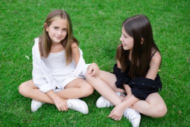 sisterhood. two sisters or friends spending time outdoors on sunny summer day. bff, sibling, girlfriend. millennial teen.