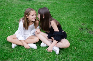 happy and lucky to have a sister. two girls outdoors in black and white clothes. good and bad. obedient and harmful. fraternal twins teen sisters