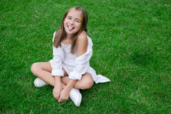 Pretty Tween Girl White Clothes Sitting Green Grass Park Sunny — Zdjęcie stockowe