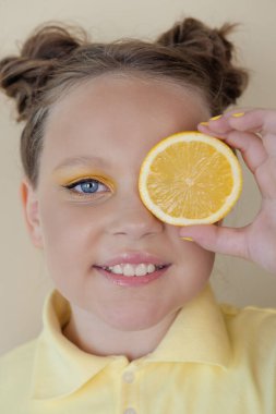 Sarı arka planda olgun limon dilimleri olan çekici bir genç kız. Meyve konsepti. yaz.