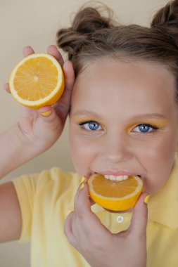 Sarı arka planda olgun limon dilimleri olan çekici bir genç kız. Meyve konsepti. yaz