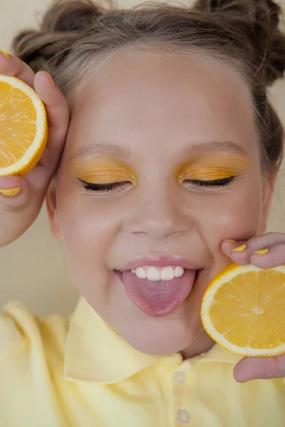 Preteenager girl with lemon on yellow background. child with fruit — Stock Photo, Image