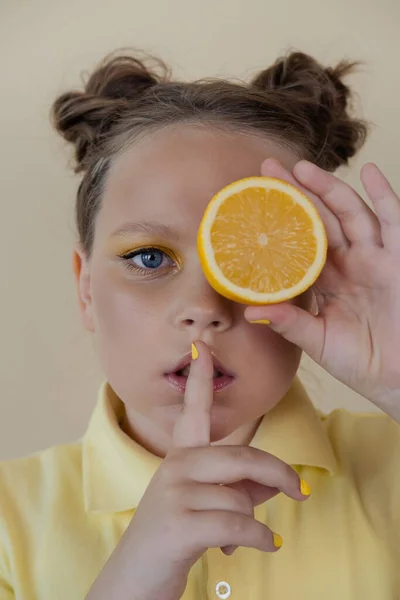 Preteenager girl with lemon on yellow background. child with fruit — Fotografia de Stock