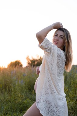 Müstakbel anne bebek bekliyor. Uzayı kopyala Hamilelik, annelik, beklenti konsepti. Dışarıda koca göbekli beyaz gecelikli güzel bir kadın.