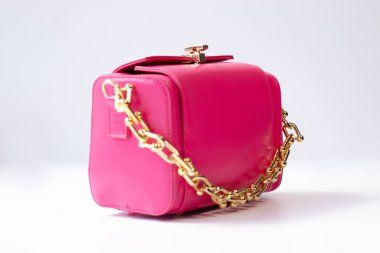 Beyaz arka planda izole edilmiş altın zincirli pembe küçük el çantası. Ürün fotoğrafçılığı. Çantalar ve çantalar.