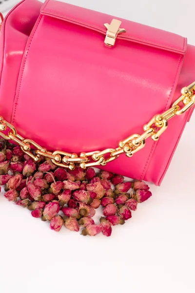 Moda fotoğrafı. Pembe el çantasının yanında küçük güller vardı. Beyaz üzerine izole edilmiş. kompozisyon fotoğrafçılığı