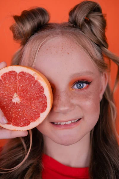 Young Girl Grapefruit Slice Orange Background Curly Hair Two Ponytails — Stock Photo, Image