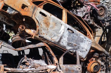 Ukrayna 'da savaş. Araba mezarlığı. Sivillerin arabalarını vurdu. Rusya 'nın Ukrayna' ya karşı savaşı. Yanmış ve havaya uçmuş bir araba. Bombardımandan sonra arabalar hasar gördü. İrpin Bucha. savaş suçları.