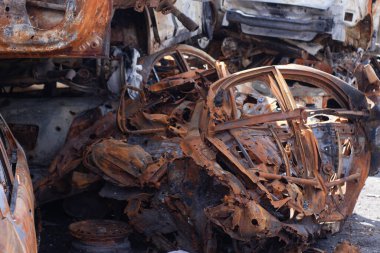 Ukrayna 'da savaş. Araba mezarlığı. Sivillerin arabalarını vurdu. Rusya 'nın Ukrayna' ya karşı savaşı. Yanmış ve havaya uçmuş bir araba. Bombardımandan sonra arabalar hasar gördü. İrpin Bucha. savaş suçları.