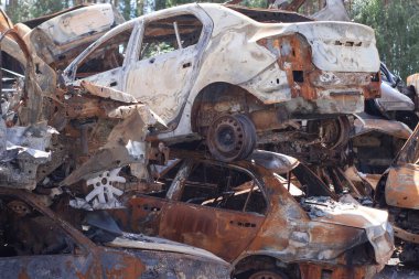 Ukrayna 'da savaş. Araba mezarlığı. Sivillerin arabalarını vurdu. Rusya 'nın Ukrayna' ya karşı savaşı. Yanmış ve havaya uçmuş bir araba. Bombardımandan sonra arabalar hasar gördü. İrpin Bucha. savaş suçları.