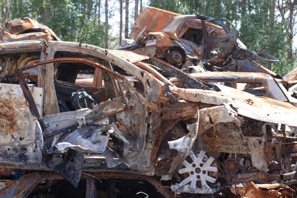 war in ukraine. Car graveyard. Shot cars of civilians. russia\'s war against Ukraine. Burnt and blown up car. Cars damaged after shelling. irpin bucha. war crimes.