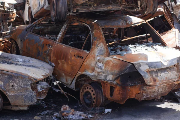 car graveyard. Burnt and blown up car. Cars damaged after shelling from russian invasion. War between Russia and Ukraine. Terror attack bomb shell. Disaster area irpin bucha.