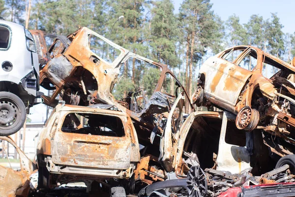 car graveyard. Burnt and blown up car. Cars damaged after shelling from russian invasion. War between Russia and Ukraine. Terror attack bomb shell. Disaster area irpin bucha.