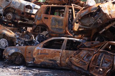 Rus ordusu ve füzesi tarafından vurulduktan sonra Irpen 'de paslı yanmış arabalar. Rusya istilası. Ukrayna 'ya karşı savaş. Savaş bölgesini boşaltmaya çalışan sivillerin tahrip edilmiş arabalarının mezarlığı..