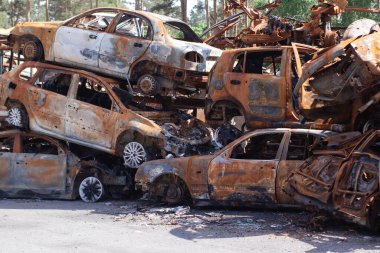 Rus ordusu ve füzesi tarafından vurulduktan sonra Irpen 'de paslı yanmış arabalar. Rusya istilası. Ukrayna 'ya karşı savaş. Savaş bölgesini boşaltmaya çalışan sivillerin tahrip edilmiş arabalarının mezarlığı..
