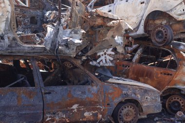 Rus ordusu ve füzesi tarafından vurulduktan sonra Irpen 'de paslı yanmış arabalar. Rusya istilası. Ukrayna 'ya karşı savaş. Savaş bölgesini boşaltmaya çalışan sivillerin tahrip edilmiş arabalarının mezarlığı..