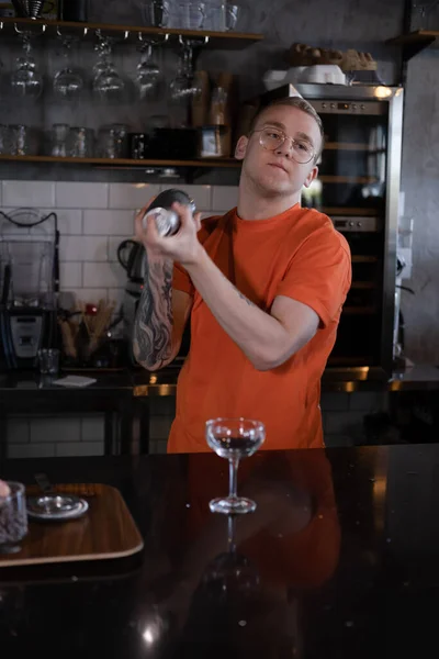 Стильный Молодой Хипстер Оранжевой Футболке Смешивающий Коктейль Темном Лофт Кафе — стоковое фото