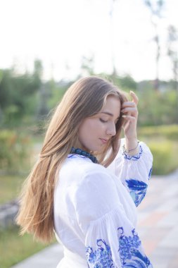 Ulusal mavi elbiseli Ukraynalı sarışın kız. Nakışlı gömlek. Genç kadın vatansever. Çekici bir kadının açık hava fotoğrafı..