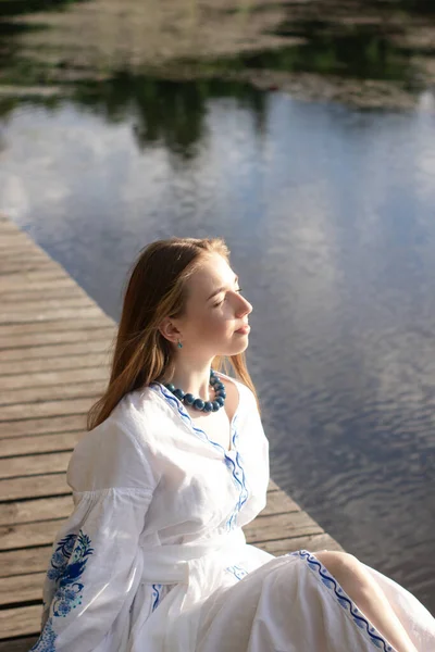 Girl Embroidered Ukrainian Shirt Sits Pier Reflection Clouds Water Lake ストック写真