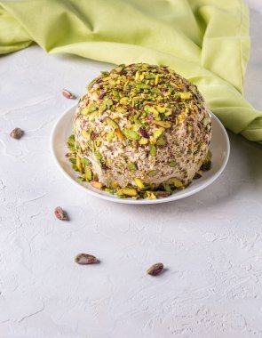 Üzerinde şam fıstığı olan susam halkası, birkaç dağınık fındık, yeşil keten peçete. Türk lokumu. Geleneksel Orta Doğu tatlıları. Yahudi, Türk, Arap tatlısı. Beyaz arka plan. Dikey yönelim