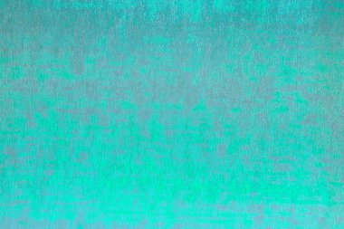 Bukalemun etkisine sahip parlak metalik ambalaj filminin pürüzsüz yüzeyi yoğun elektrik yeşili ve gri noktalı. Kopyalama alanı olan soyut arkaplan. Yatay oryantasyon. Yukarıdan görüntüle.