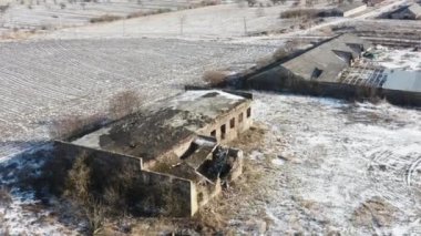 Tarım alanının yakınındaki terk edilmiş bir sanayi binasının havadan görüntüsü. Kış zamanı