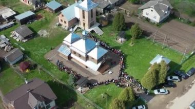 Rahipler, ahşap kilisenin yanında Paskalya kutsanmış Hristiyanları kutsar. Ukrayna 'da Paskalya kutlaması gelenekleri. Hava Aracı görünümü.