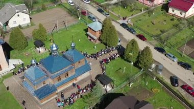 Rahipler, ahşap kilisenin yanında Paskalya kutsanmış Hristiyanları kutsar. Ukrayna 'da Paskalya kutlaması gelenekleri. Hava Aracı görünümü.