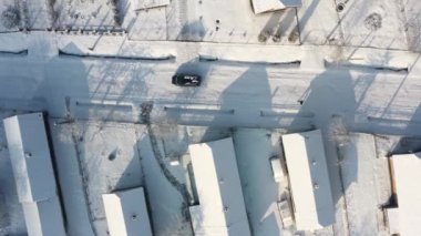 Karlı yolda giden arabanın hava aracı görüntüsü, insanlar yürüyor, manzarası çok güzel. Kış mevsimi