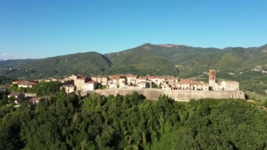 Resimli dağlar ve ormanlar arasında yer alan küçük bir kasabaya bakan hava manzarası. İtalya 'da etkileyici bir mimari.