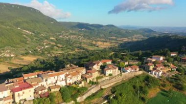 Resimli dağlar ve ormanlar arasında yer alan küçük bir kasabaya bakan hava manzarası. İtalya 'da etkileyici bir mimari.