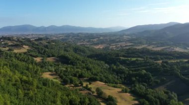 Panoramik doğal manzara. Dağlar, yeşil ormanlar ve bahçeler, mavi gökyüzü ve güzel güneşli bir gün. Pan tekniğiyle hava görünümü