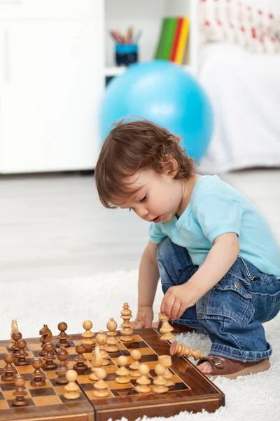 Tout-petit garçon jouant avec des pièces d'échecs — Photo