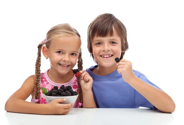 Mutlu sağlıklı çocuklar taze böğürtlen yeme — Stok fotoğraf