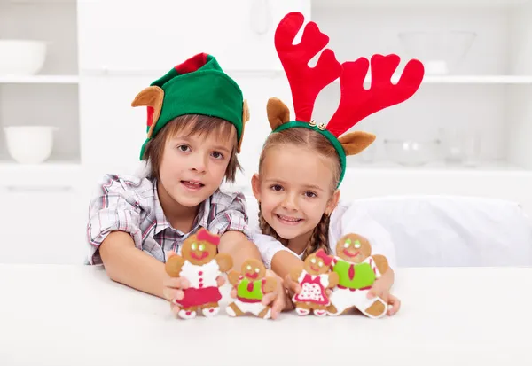 Happy christmas kids holding decorated gingerbread — Stock Photo, Image