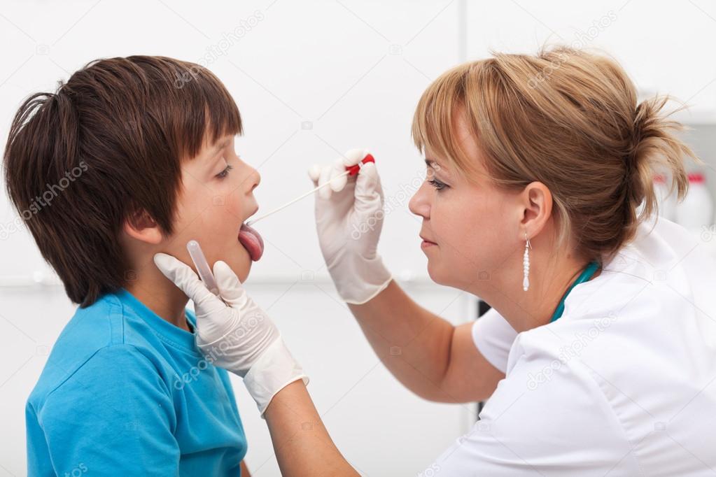 Health professional taking saliva sample from little boy